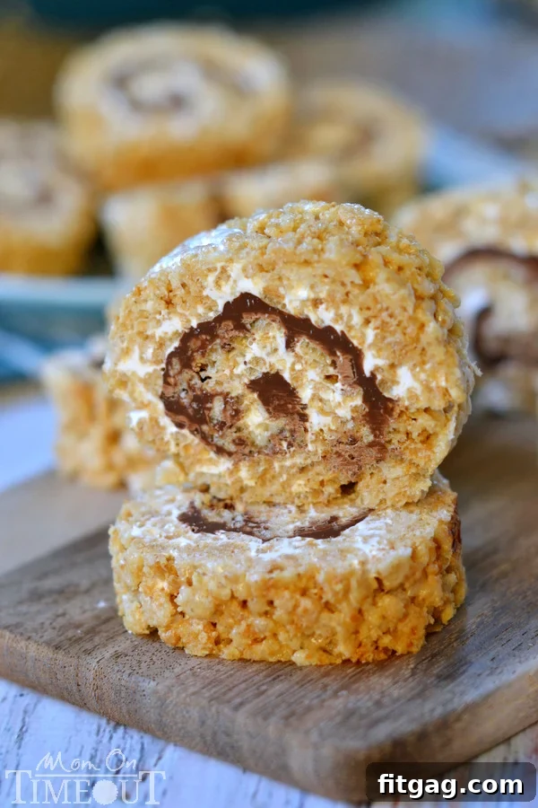 Sliced S'mores Rice Krispies Treats Pinwheels, showcasing the beautiful spiral layers of marshmallow, chocolate, and graham cracker cereal, ready to serve.