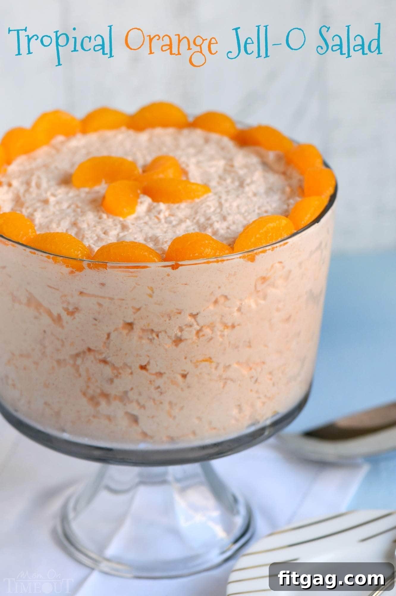 A vibrant bowl of Tropical Orange Jello Salad, ready to serve at a party. This easy recipe combines orange, pineapple, and coconut for a refreshing dessert.