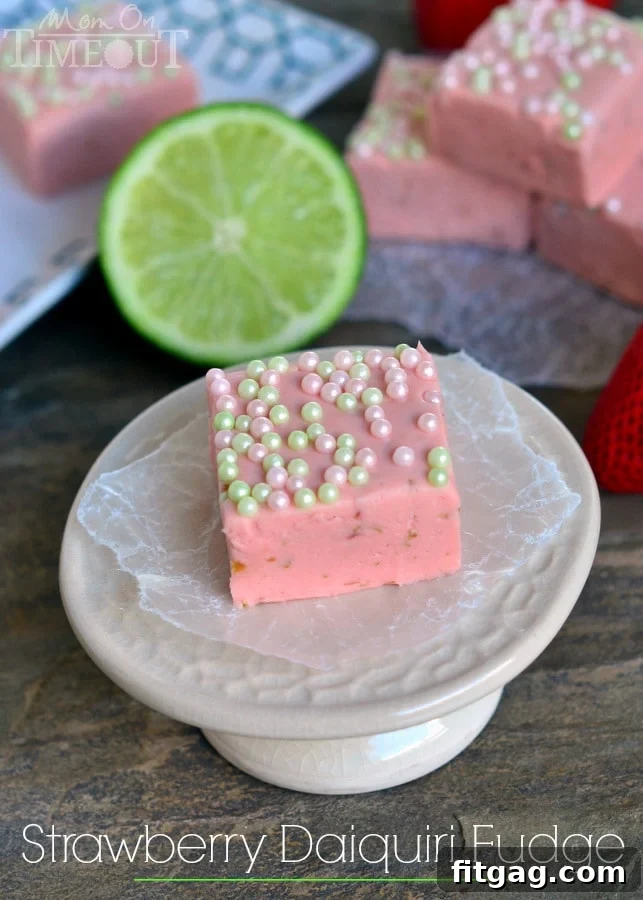 A vibrant pink Strawberry Daiquiri Fudge square topped with colorful pink and green sugar pearls, ready to serve.