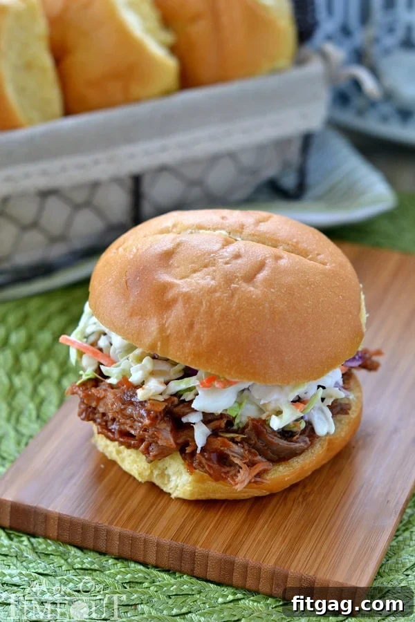 Juicy Slow Cooker Root Beer Pulled Pork Sandwiches served on buns with a side of coleslaw.