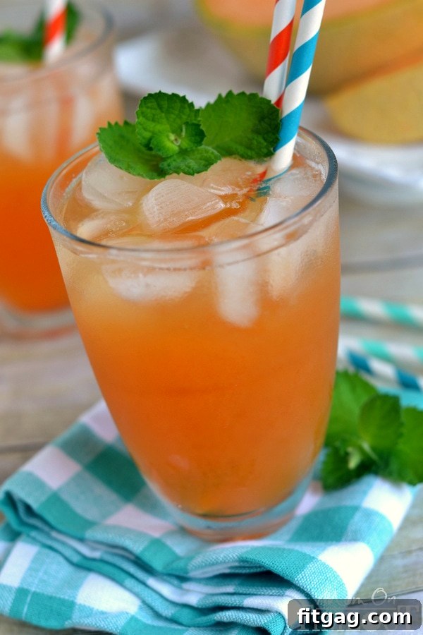Close-up of Melon Mint Agua Fresca in a glass with mint garnish and melon cubes, highlighting its beautiful natural color and refreshing texture. #agua fresca #melon #mint #refreshingdrink
