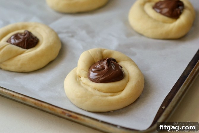 Shaping sweet rolls into nests and filling with chocolate hazelnut spread