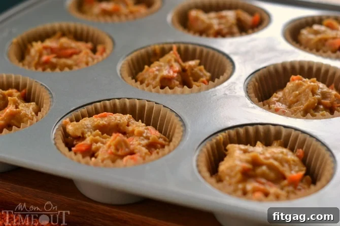 Pumpkin carrot cake cupcake batter being mixed, showing a rich orange color before baking.