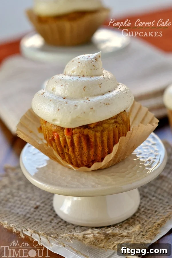 Vertical shot of Pumpkin Carrot Cake Cupcakes with generous Maple Cream Cheese Frosting, ready for a fall gathering. Tags: #dessert #recipe #pumpkin #maple #cupcakes