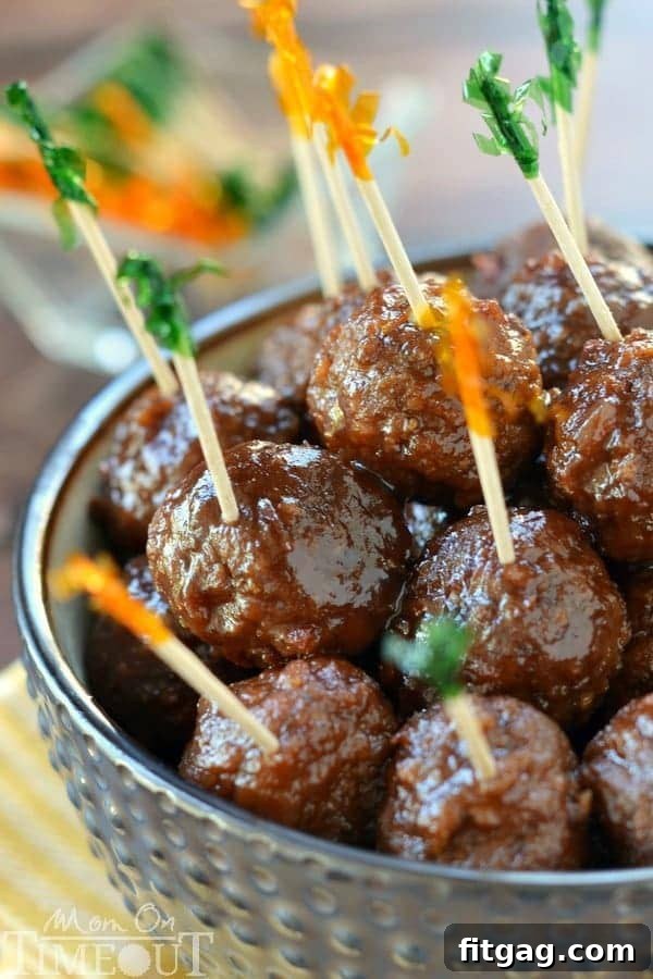 Crock-Pot Party Meatball Bites 5 Close-up of cocktail meatballs with toothpicks, showing the glossy grape jelly and chili sauce coating.