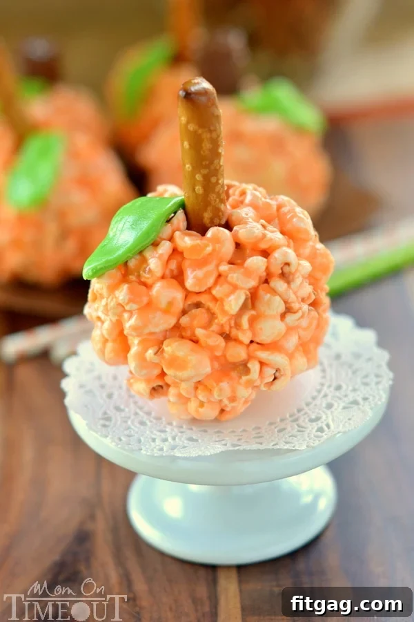 Autumn Pumpkin Popcorn Bites 5 A festive spread of homemade Pumpkin Popcorn Balls with charming stems and leaves, ideal for autumn holidays.