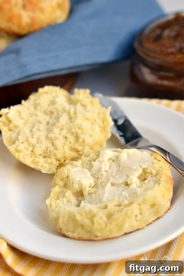 Buttery Flaky Biscuits: A Simple Delight A golden, flaky small batch biscuit, split open and generously buttered, resting on a white ceramic plate, ready to be enjoyed.