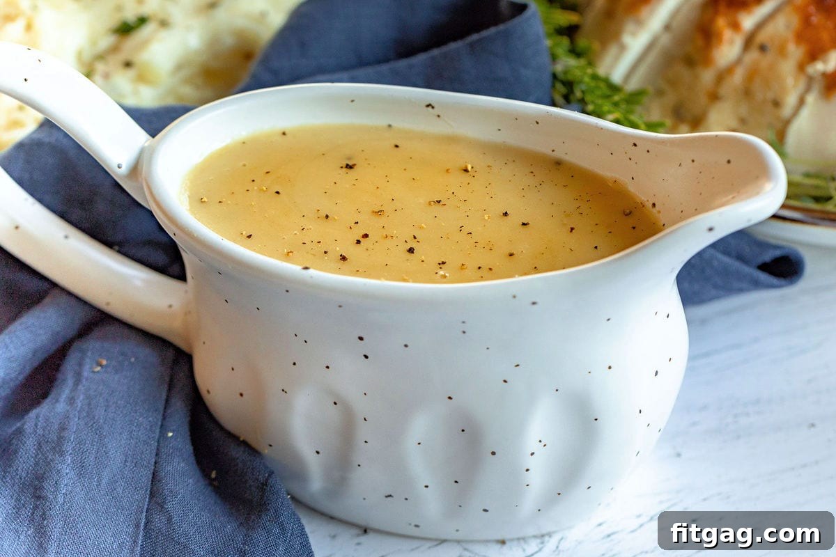 A large, elegant gravy boat proudly displays a generous amount of rich, warm turkey gravy, poised and ready to be served to eager guests at the dinner table.