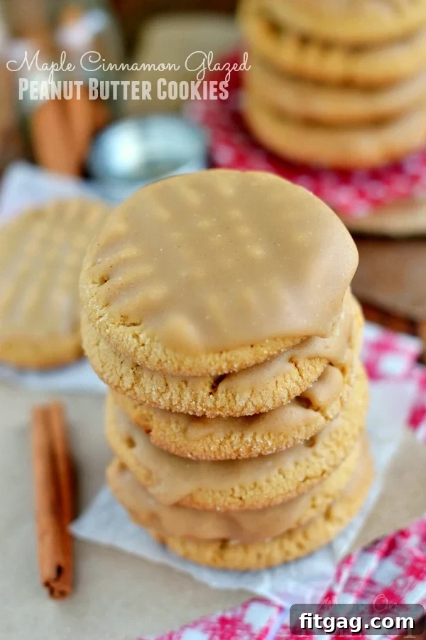 Stacked maple cinnamon glazed peanut butter cookies on parchment paper, showcasing their perfect texture and inviting glaze