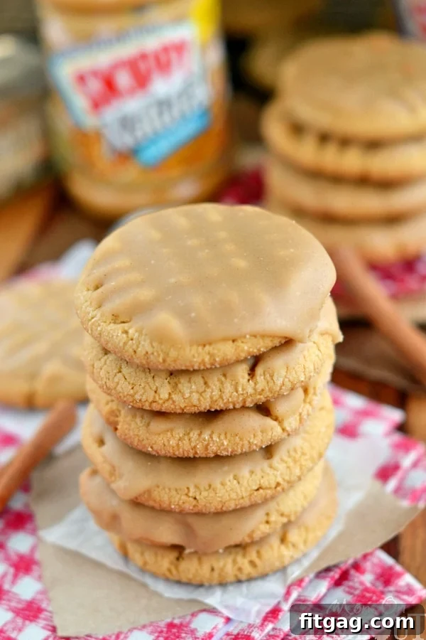 Freshly baked peanut butter cookies cooling on parchment paper before glazing