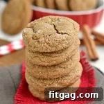 Ginger molasses cookies stacked on red burlap, ready to be enjoyed.
