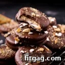 no bake ritz cracker sandwich cookies with marshmallow filling and dipped in chocolate stacked on small wire rack. tops of cookies have crushed graham crackers and miniature marshmallows.