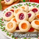 christmas plate piled high with thumbprint cookies filled with apricot and raspberry jam.