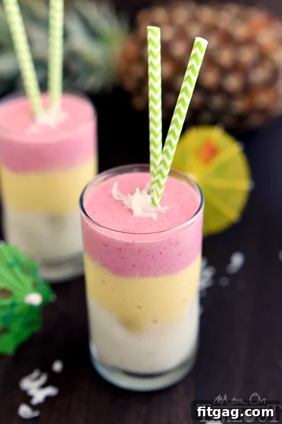 A refreshing glass of layered Tropical Sunrise Smoothie, a healthy and delicious way to start your day with tropical fruit flavors.