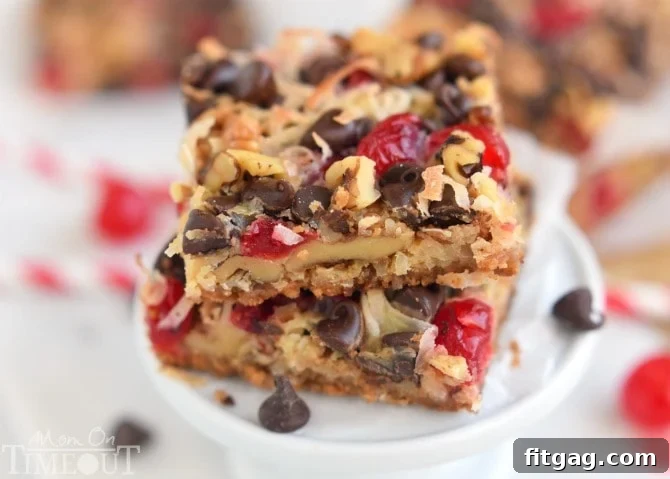 A close-up view of freshly baked Cherry Coconut Magic Bars, showcasing the vibrant red cherries, melted chocolate chips, and golden toasted coconut on a graham cracker crust. Ideal for an easy dessert recipe.