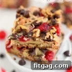 Small square of Cherry Coconut Magic Bars, showing its chewy interior and toasted topping.