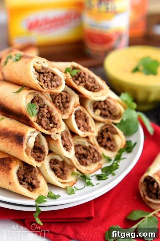 Oven-Crisp Beef Flautas with Creamy Queso Dip 5 A tray of freshly baked beef flautas, golden and crispy, ready to be served.