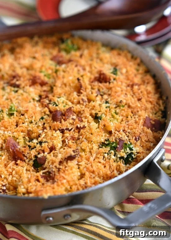 Close-up of Skillet Bacon and Broccoli Macaroni and Cheese, showing the rich texture, bacon bits, and green broccoli florets.