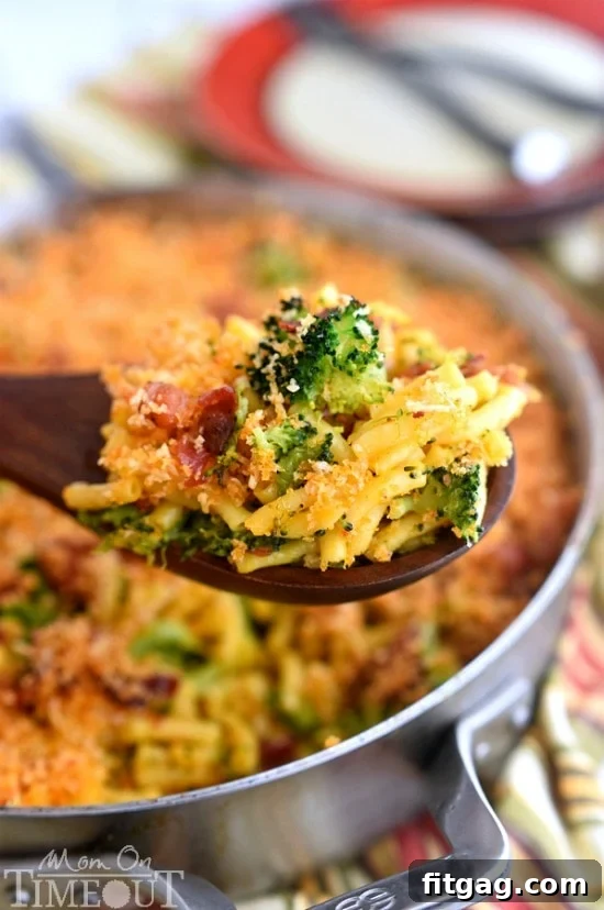 Serving of Skillet Bacon and Broccoli Macaroni and Cheese in a white bowl, showcasing the generous amount of broccoli and bacon.