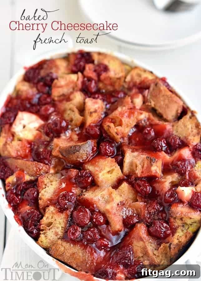 A delectable slice of Baked Cherry Cheesecake French Toast Casserole served on a plate, garnished with fresh cherries and powdered sugar, highlighting its rich layers.