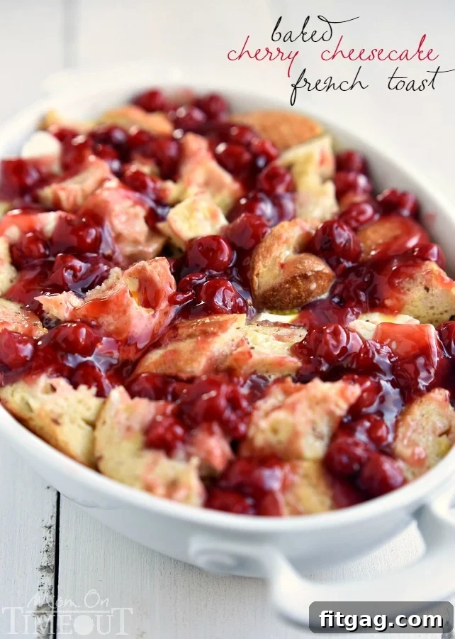 A rustic ceramic baking dish filled with Baked Cherry Cheesecake French Toast Casserole, freshly pulled from the oven, with a golden-brown top.