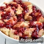 Baked Cherry Cheesecake French Toast Casserole ready to serve, a golden-brown top with cherry pockets