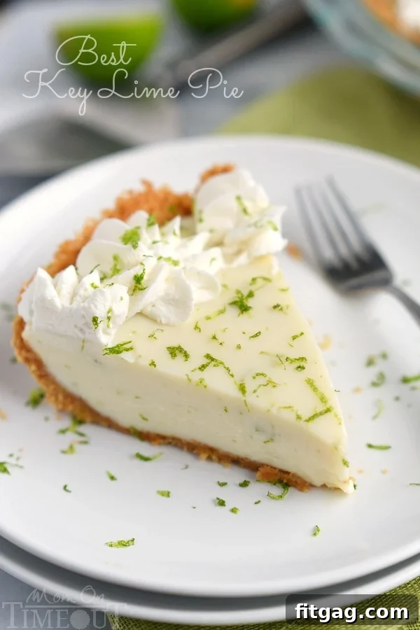 The Best Key Lime Pie with a slice taken out, showcasing the creamy green filling and golden crust. A perfect tart and sweet dessert for any occasion.