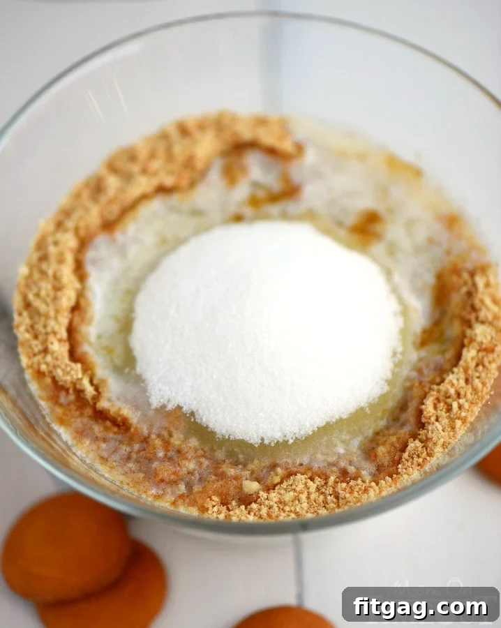 Mixing the Nilla Wafer crumbs with melted butter and sugar for an easy pie crust recipe.