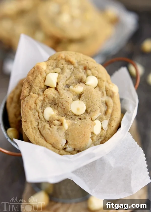 A stack of golden Brown Butter White Chocolate Macadamia Nut Cookies on a cooling rack, highlighting their perfect texture and delicious appearance.