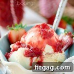 A bowl of vanilla ice cream with strawberry topping on top.