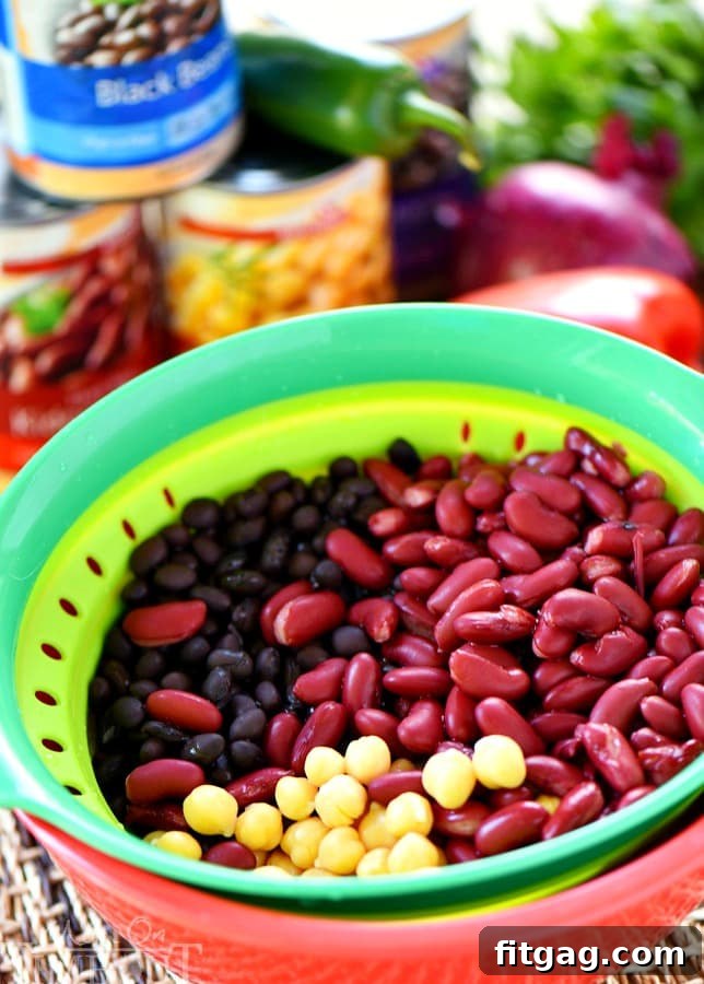 Three types of beans – kidney, black, and garbanzo – freshly rinsed and drained, ready for the salad