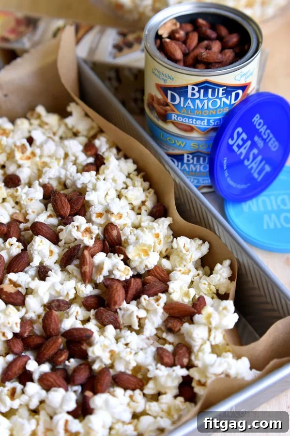 Sweet & Salty Almond Popcorn Crunch 7 Delicious salted caramel popcorn with almonds in a bowl, ready to be enjoyed as a snack. | MomOnTimeout.com