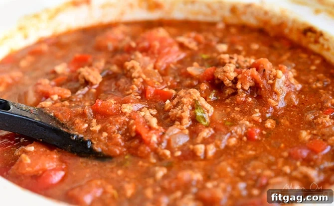 This easy homemade Spaghetti Sauce recipe is perfect for busy weeknights! Made in the slow cooker, this delicious spaghetti sauce is full of flavor and makes a large batch which is great for freezing. Enjoy with your family tonight! Make it with or without meat - your choice! // Mom On Timeout #spaghetti #sauce #recipe #dinner #easy #recipes #slowcooker #crockpot Slow Cooker Spaghetti Sauce simmering