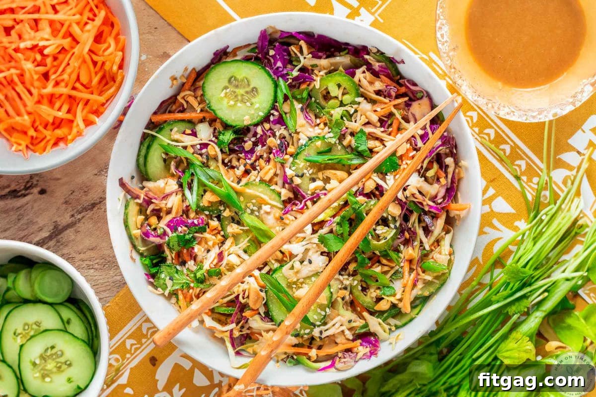 Thai Peanut Salad with Crunchy Veggies and Lime Dressing 5 Overhead shot of large white bowl with summer thai salad that has been tossed with peanut dressing. Two chopsticks are laid on top of the bowl.