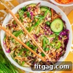 Thai Peanut Salad with Crunchy Veggies and Lime Dressing 9 Overhead shot of large white bowl with summer thai salad that has been tossed with peanut dressing. Two chopsticks are laid on top of the bowl.