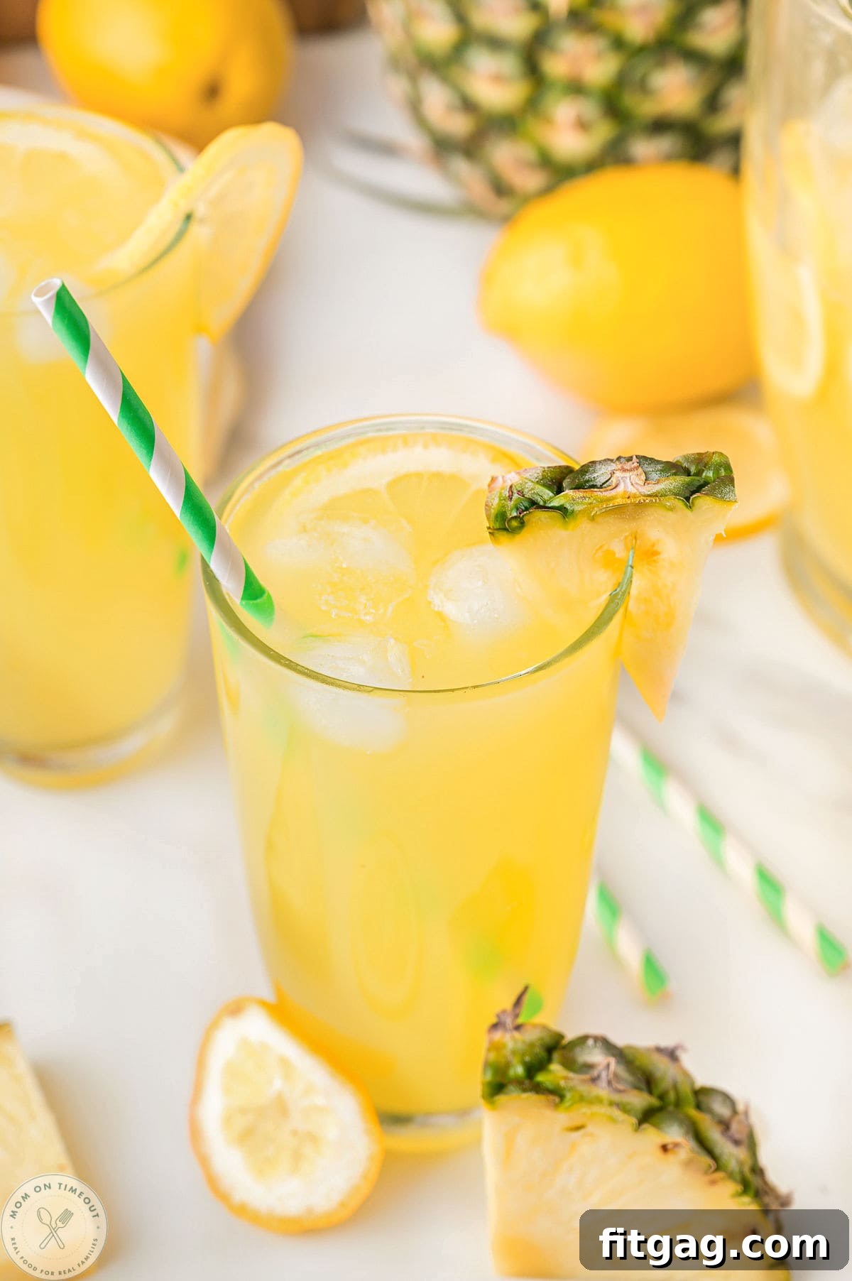 Glass of pineapple lemonade with a pineapple wedge garnish on rim.